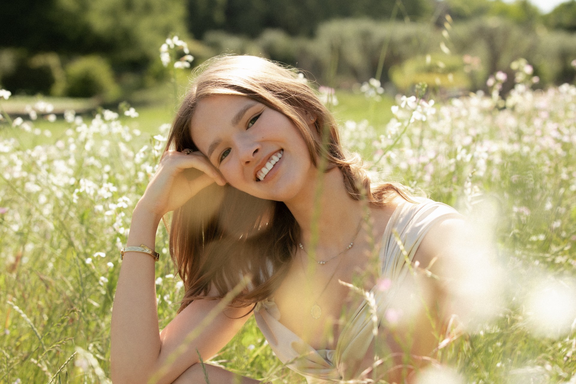 Emma Brewer smiling in a field of wildflowers